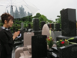 作詞家、木下龍太郎氏の墓前で手をあわせる原田悠里